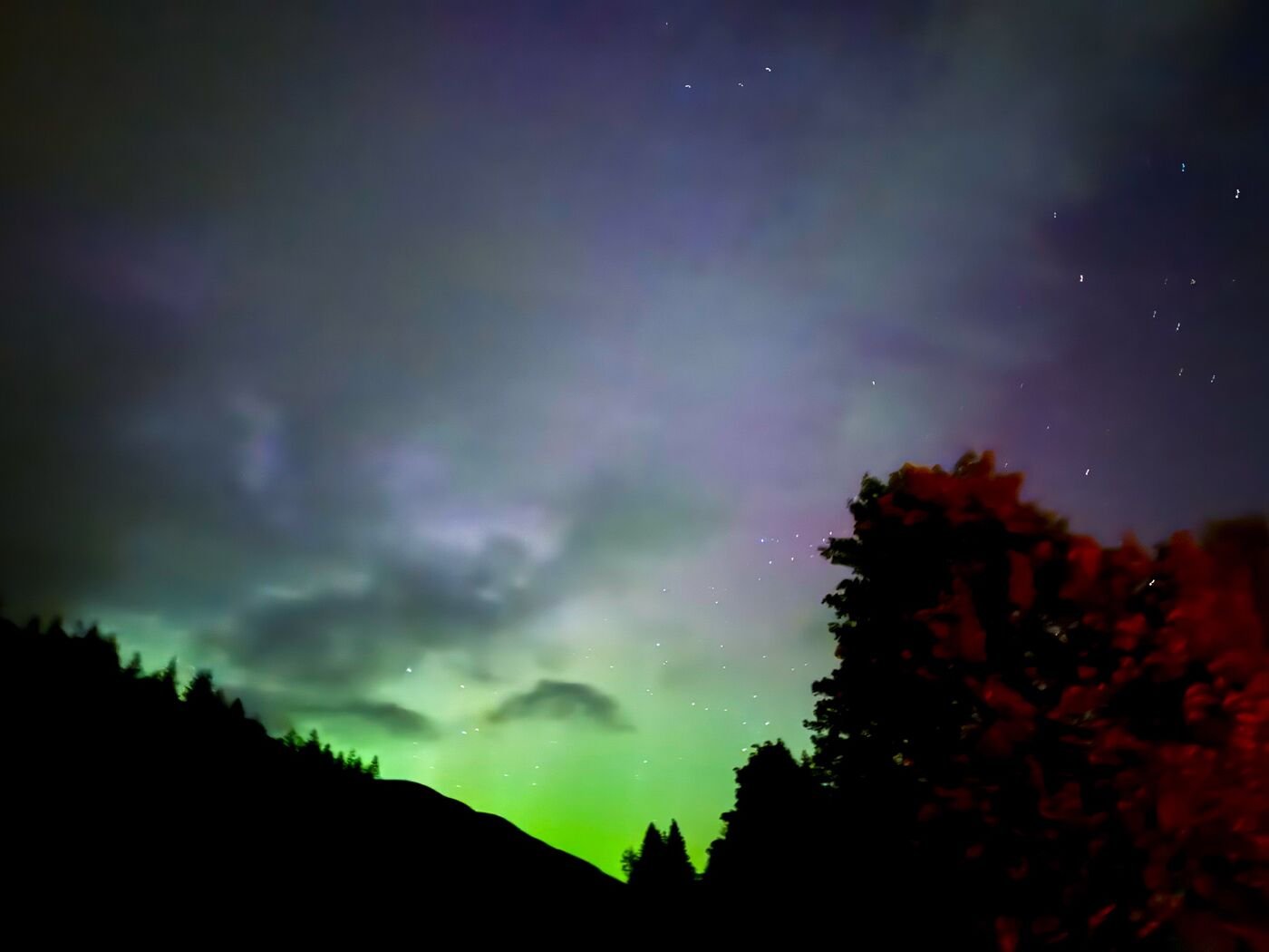 Green northern lights over a Scottish hillside at night, photographed by Eccentric Routes