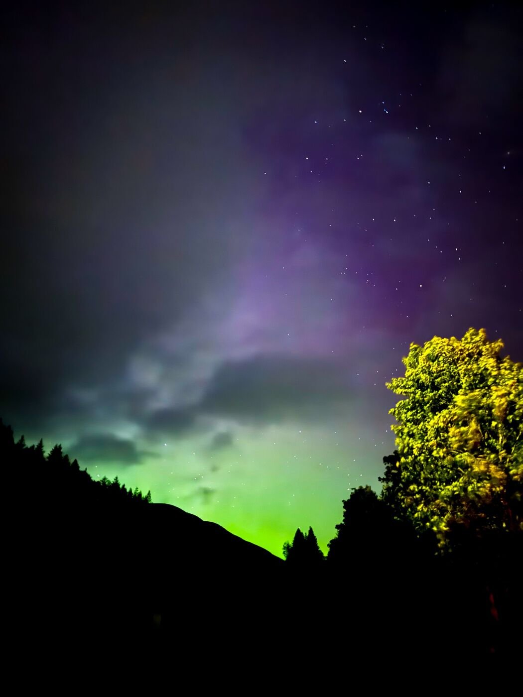 Green northern lights over a Scottish hillside, travel photography by Eccentric Routes
